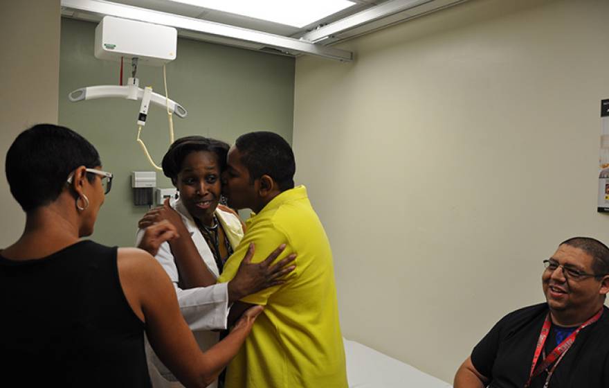 Zulmira T. (left) watches as her son Kobe B. (yellow shirt) expresses his delight in seeing Dr. Emma Simmons. Alfonso Guzman, a licensed vocation nurse assigned to Kobe B., is seen on the right.