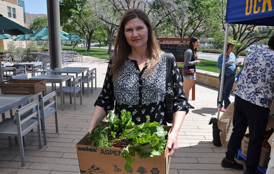Dana Taylor picks up her produce at inaugural FarmShare event.