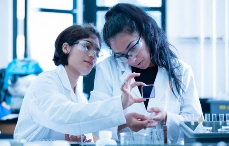 Two students of color working in a lab