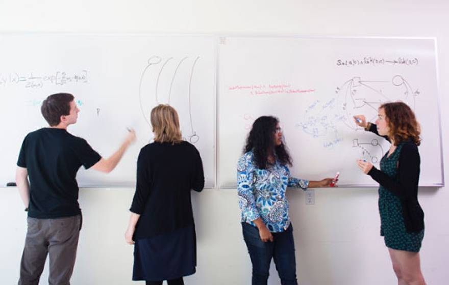 Four students at whiteboards