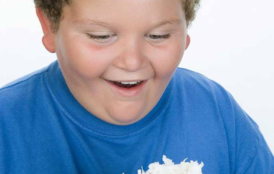 overweight boy with slice of cake (iStock)