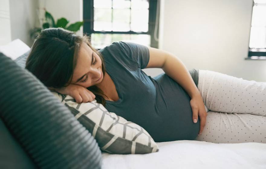 A pregnant woman relaxed on a bed