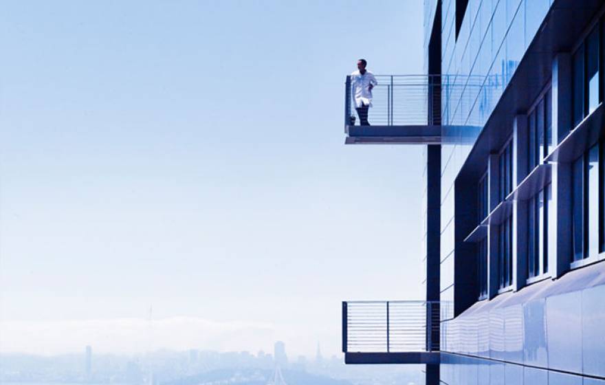 Researcher on a balcony with San Francisco skyline behind