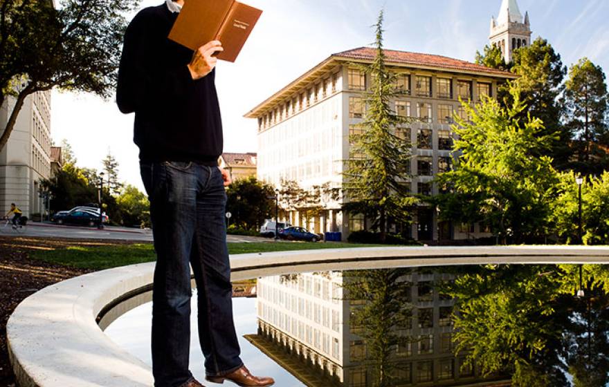 student reads book near Berkeley Campanile