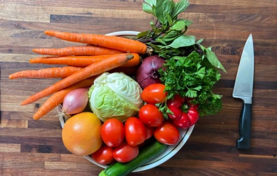 A plate of raw vegetables next to a knife