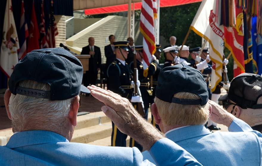 Korean War veterans saluting the American flag.
