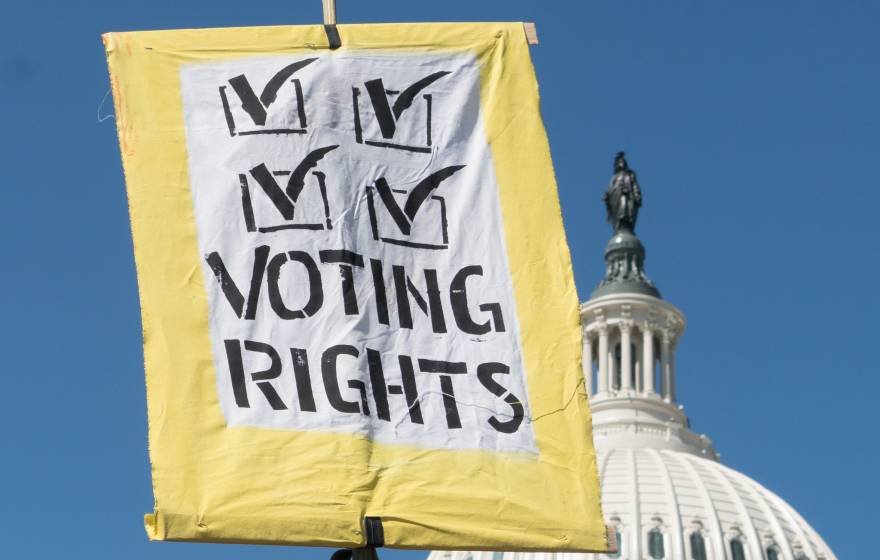 A voting rights sign held up in front of the U.S. Capitol