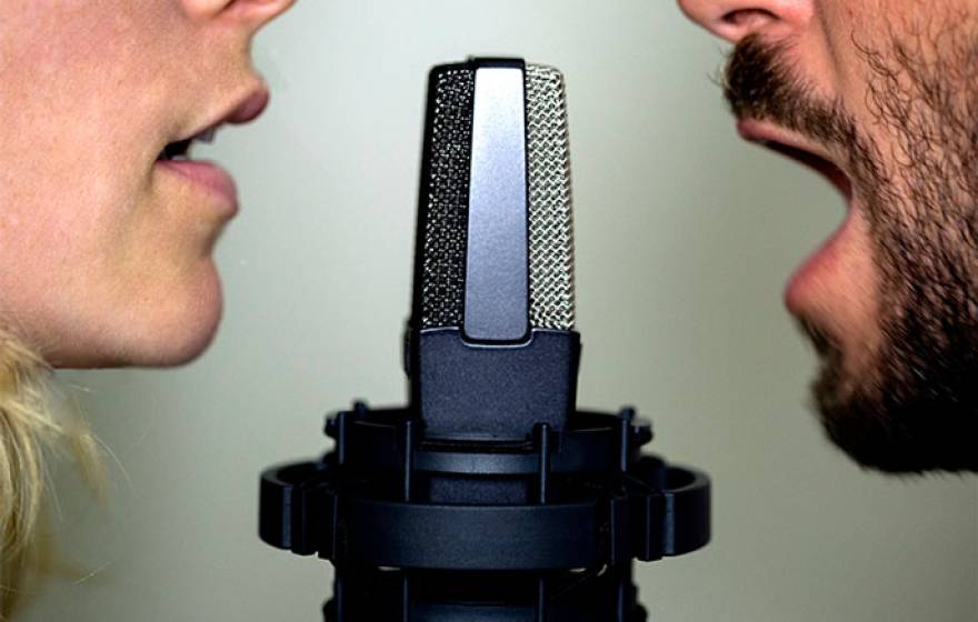 A man and a woman at a microphone