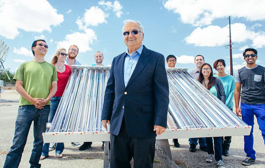 Professor Roland Winston and some of his student researchers and their solar collector. Winston in front