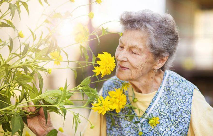Older woman smelling flowers