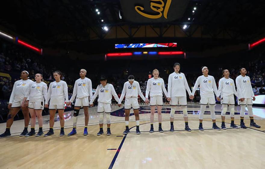 Women standing for anthem at basketball game