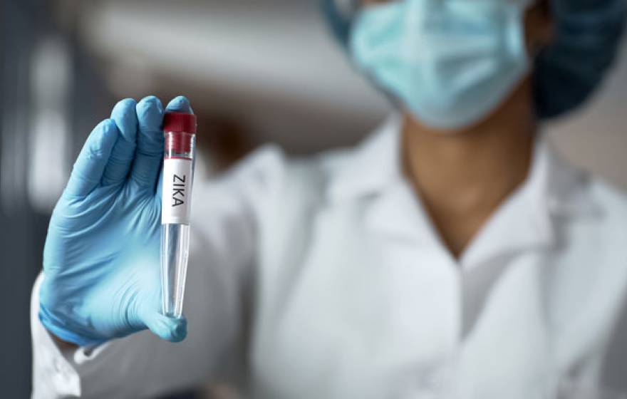 Woman holding a vial of blood in a lab