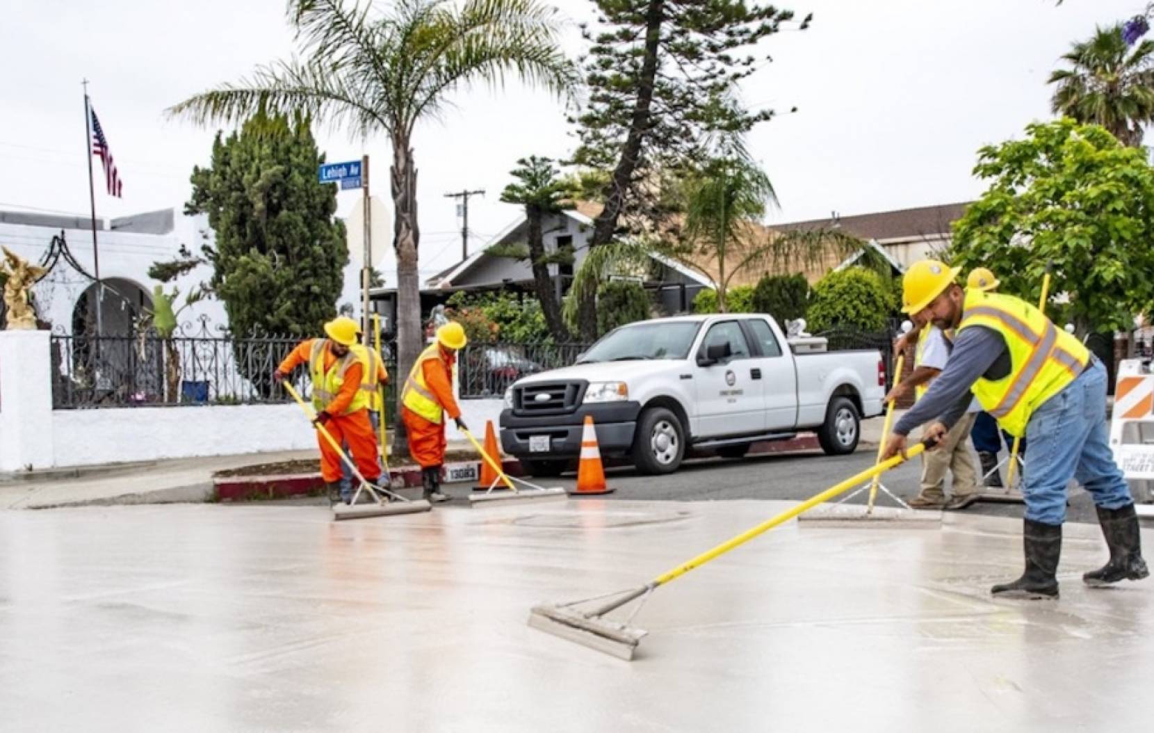 Workers applying cool pavement technology to a street in Pacoima