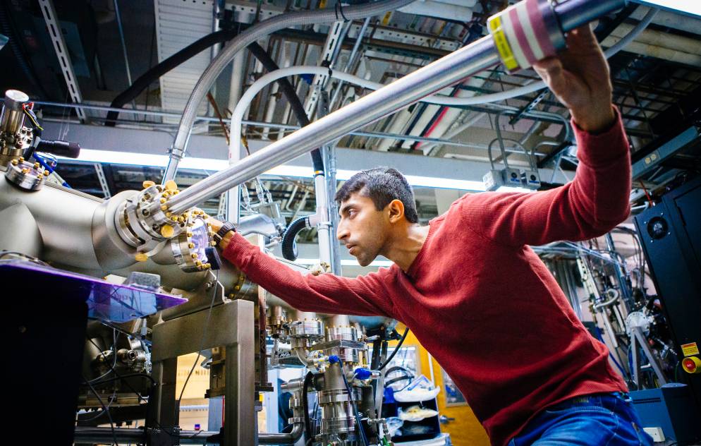 A grad student holds a tube as part of an engineering project