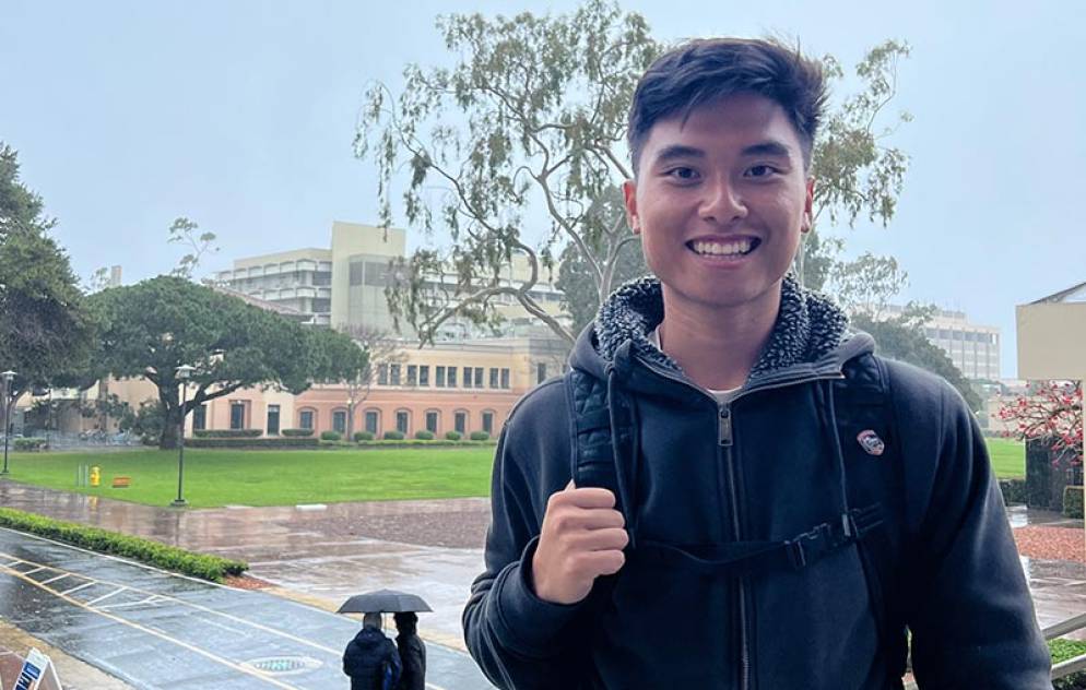 Smiling young man at UC Santa Barbara on a rainy day