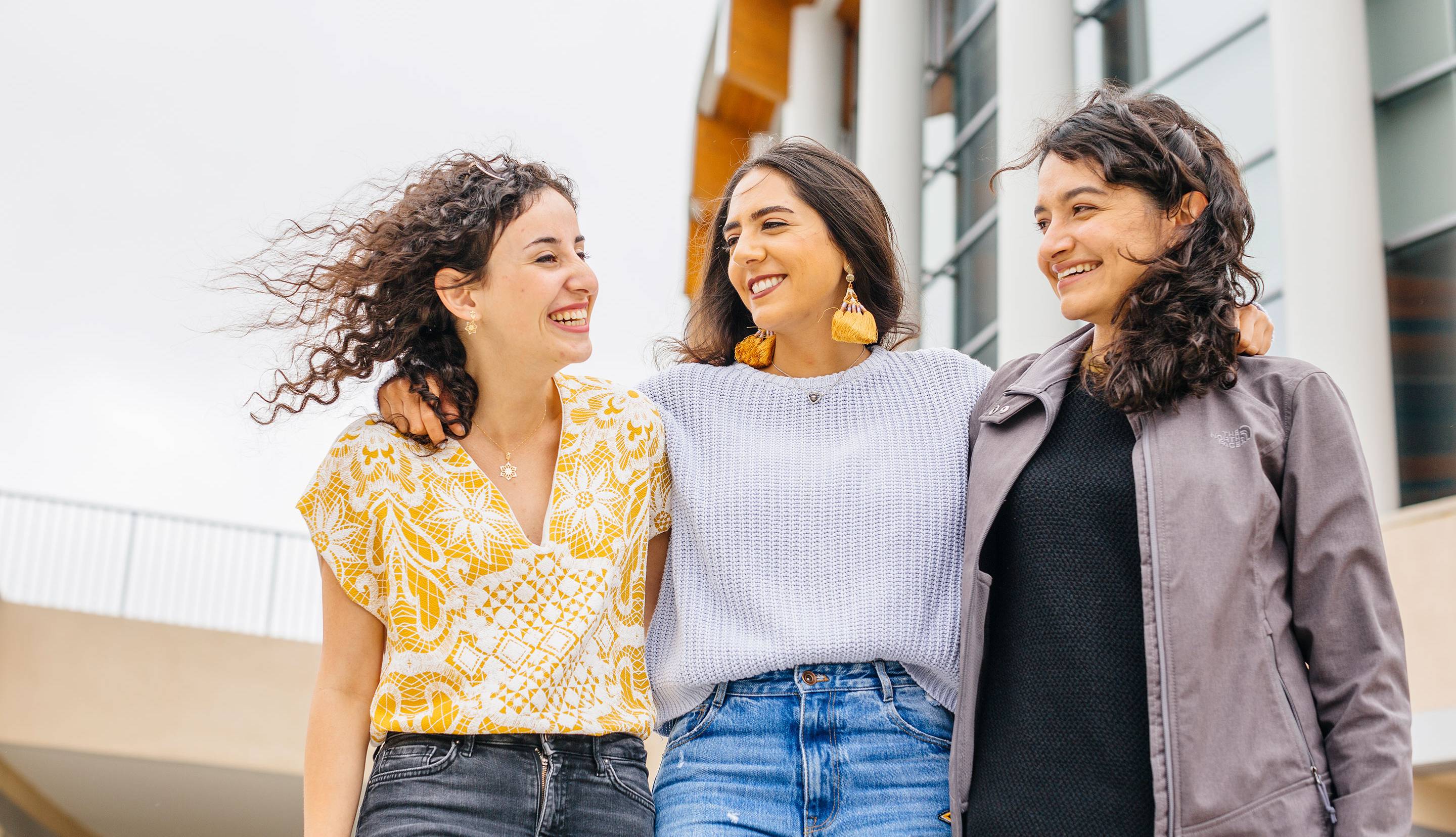 Three women standing together and smiling