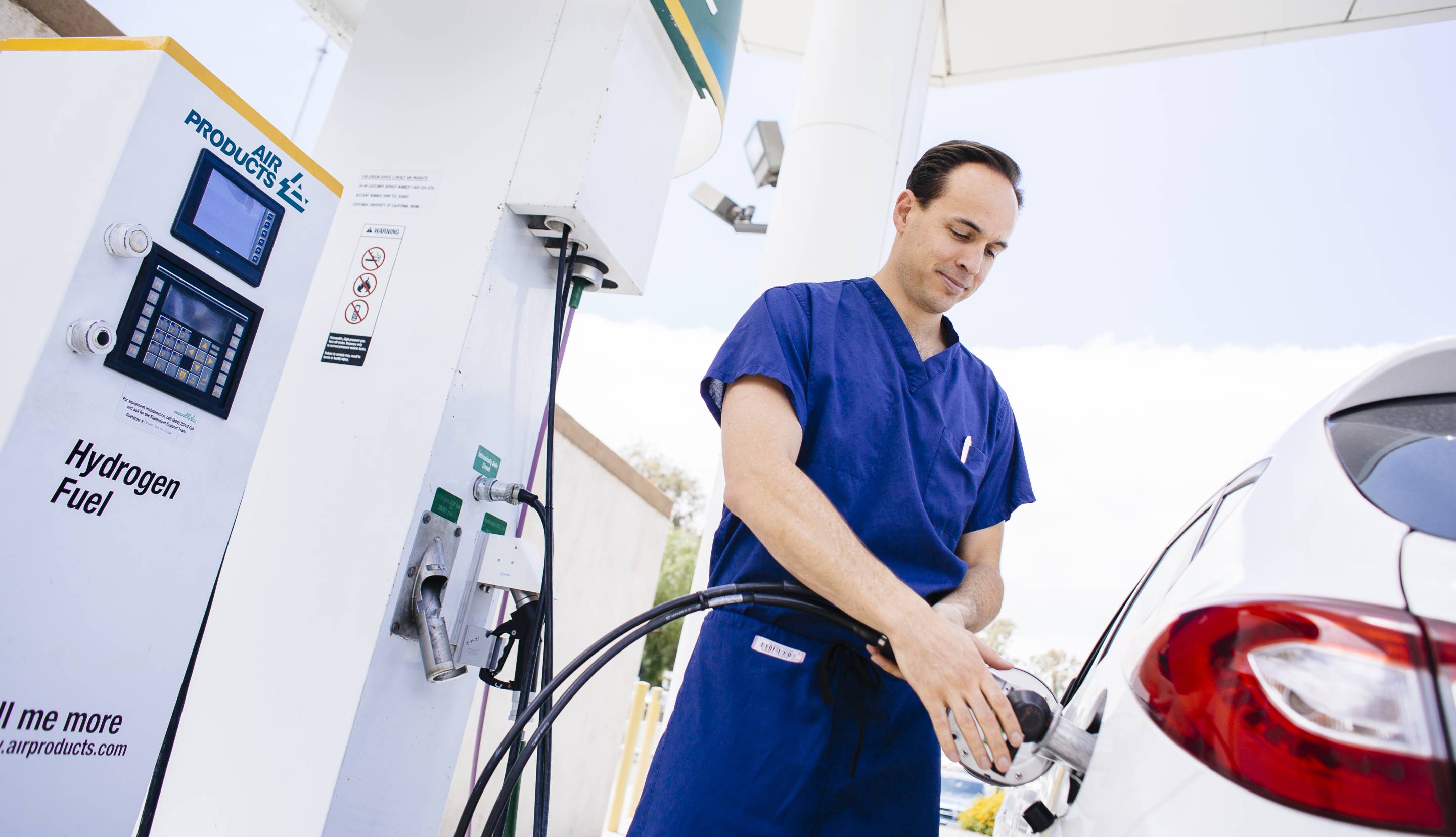 A man refueling a hydrogen fuel car