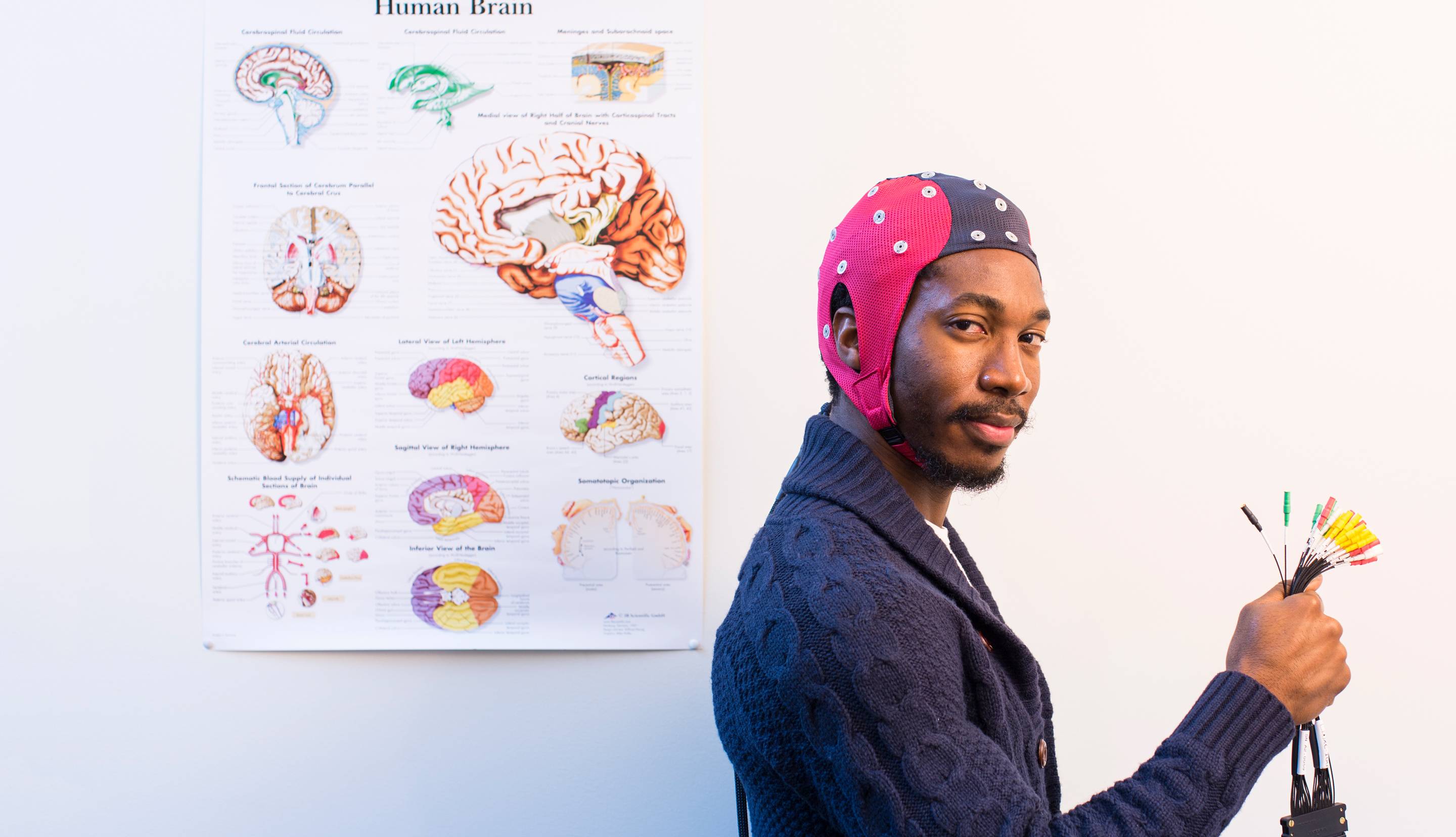 Young Black man in headgear next to a map of the human brain