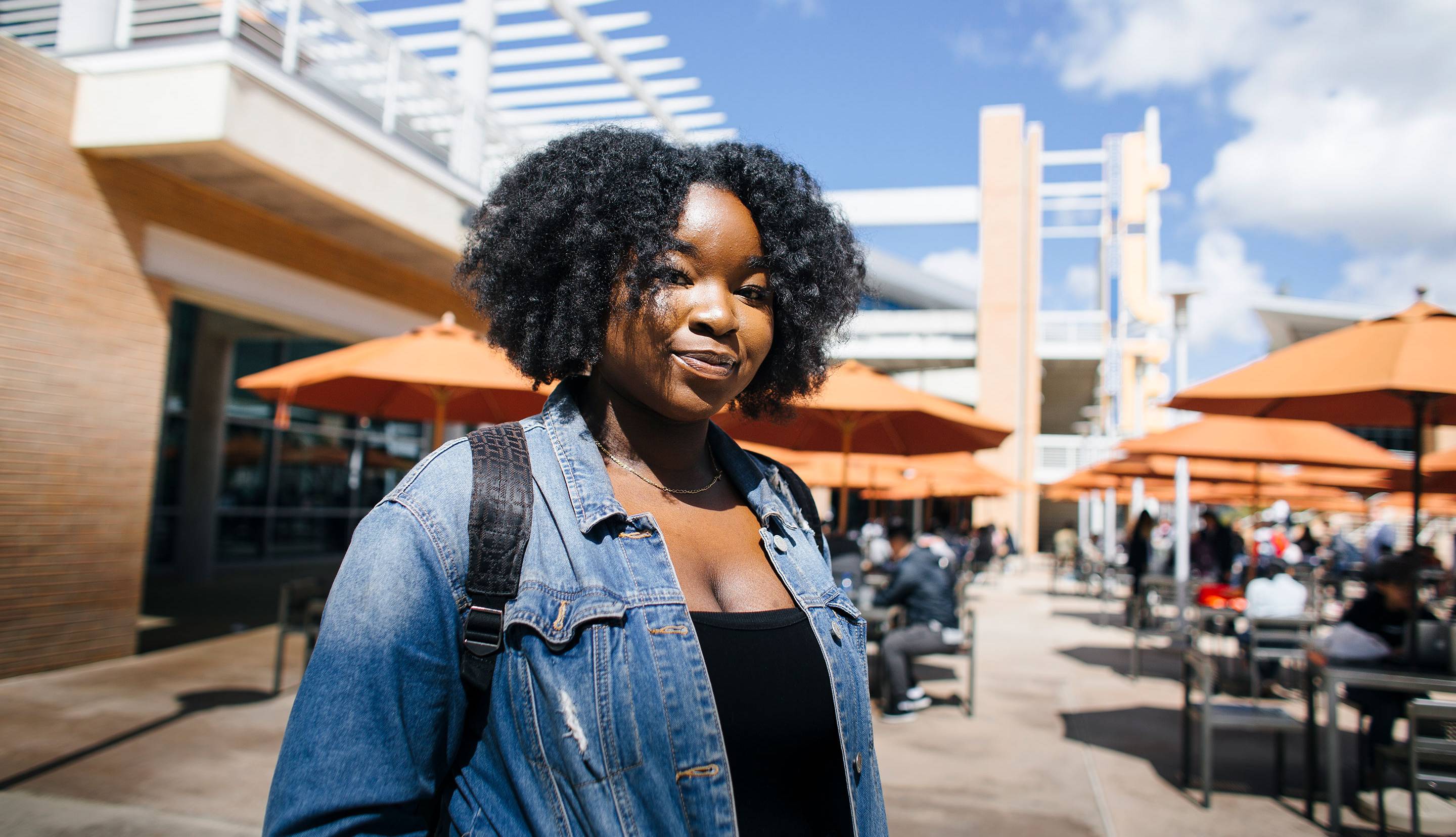 Student portrait with a campus in the background