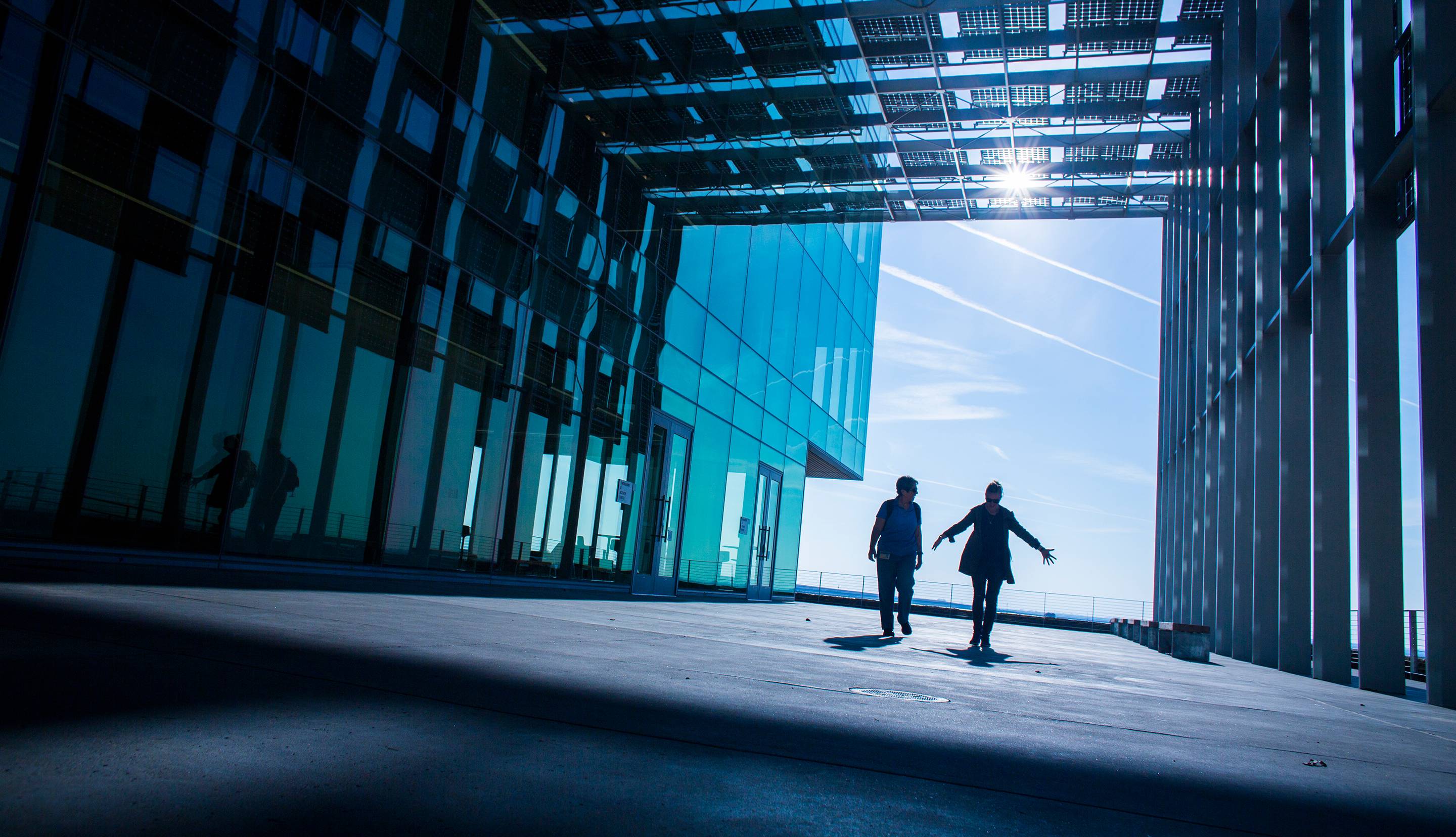 Two people walking through a solar-powered building