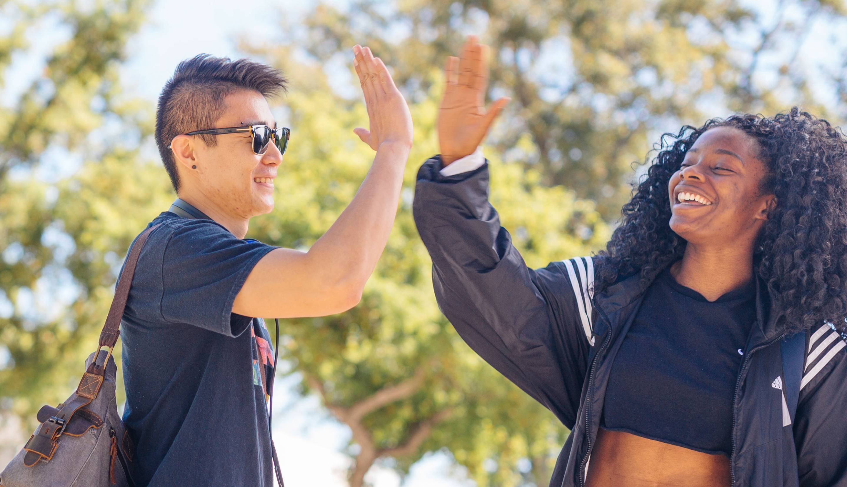 Two students on campus giving each other a high five