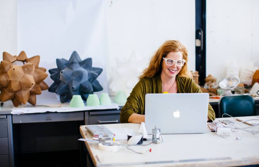 Woman in a creative studio sitting at a laptop