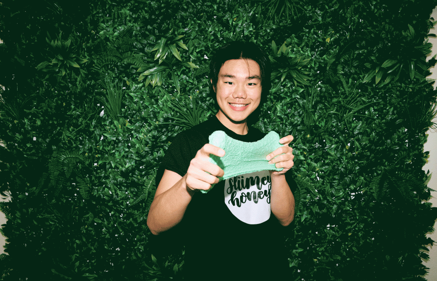 Mark Lin playing with slimey with a background of leaves.