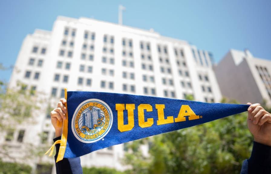 Campus banner with UCLA on it and a downtown LA building in the background. 