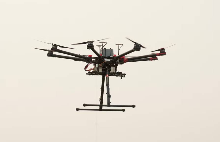 An airborne drone against a hazy, smoke-filled sky