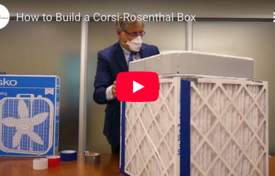 A person wearing a suit and breathing mask demonstrating how to build a homemade air filter