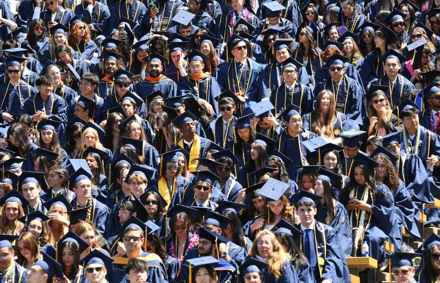A sea of college students in caps and gowns at graduation