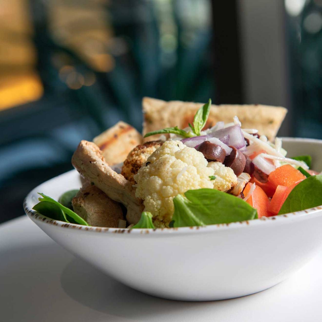 A bowl of cauliflower, spinach, tofu and other plant-based foods