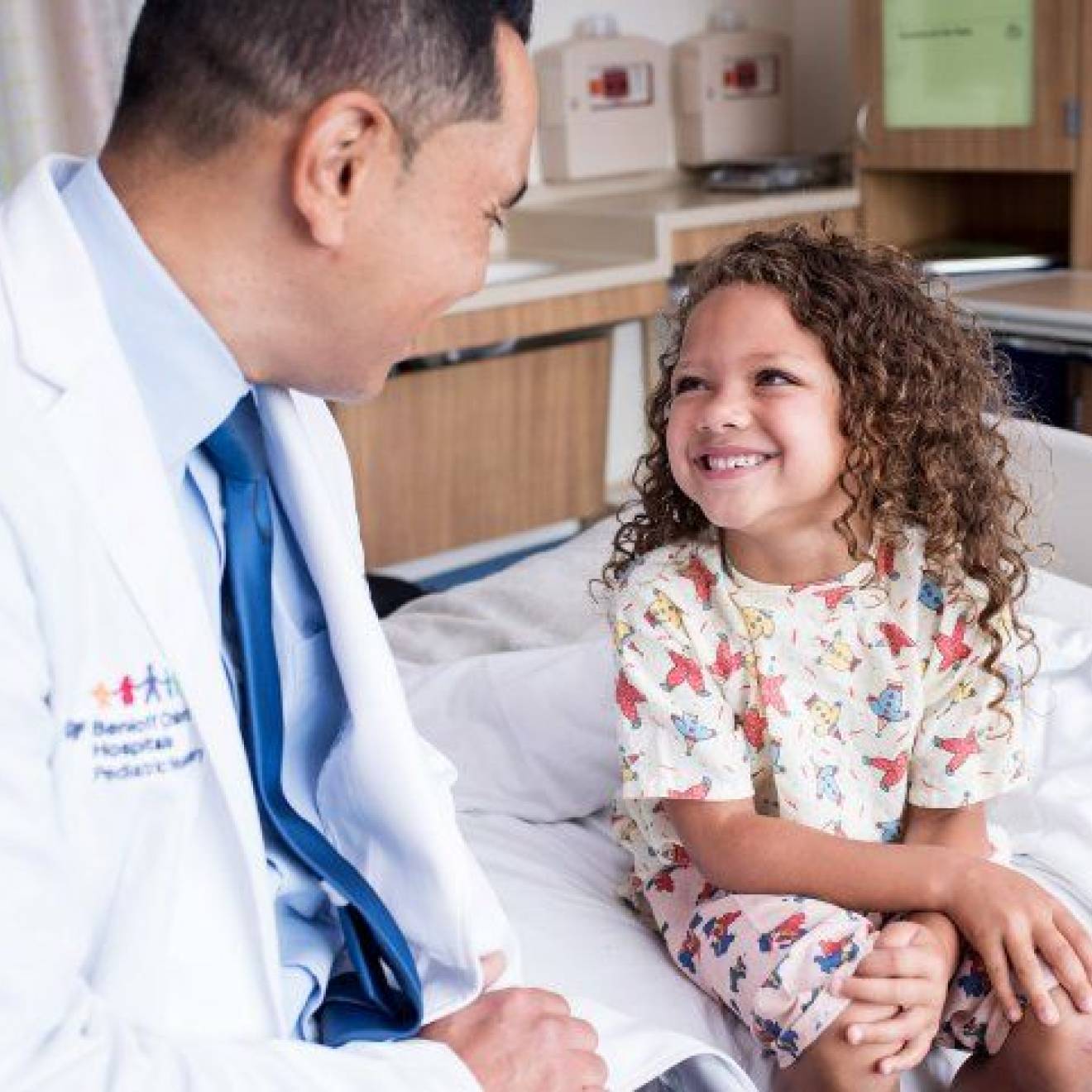 Kurtis Auguste, MD, a pediatric neurosurgeon, talks with a child in the Pediatric Brain Center at the UCSF Benioff Children’s Hospital.