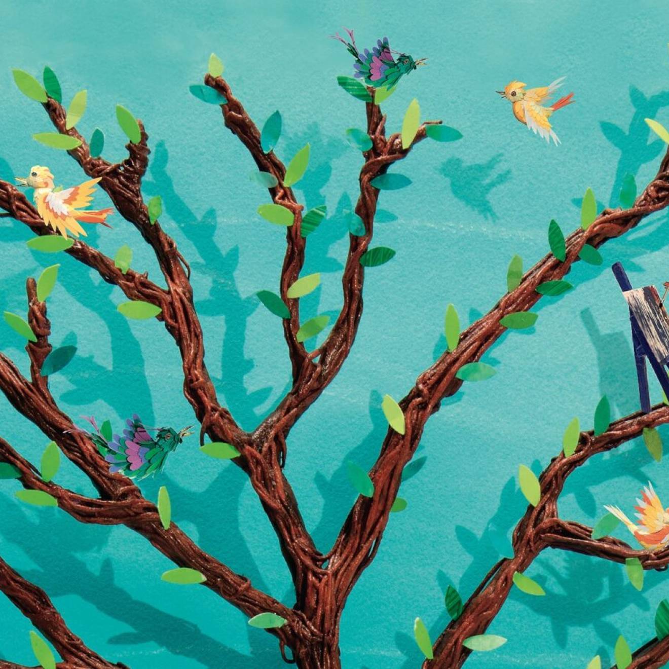 Illustration of a brown tree against a turquoise background, with tiny people and birds on its branches