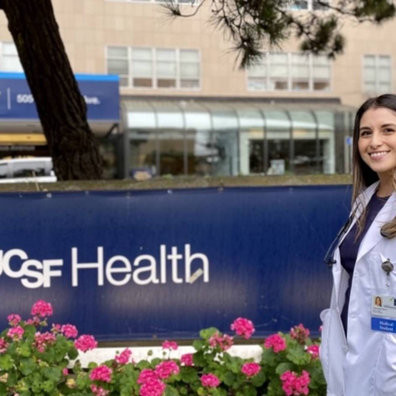 Vanessa Mora in a white coat in front of UCSF Health sign