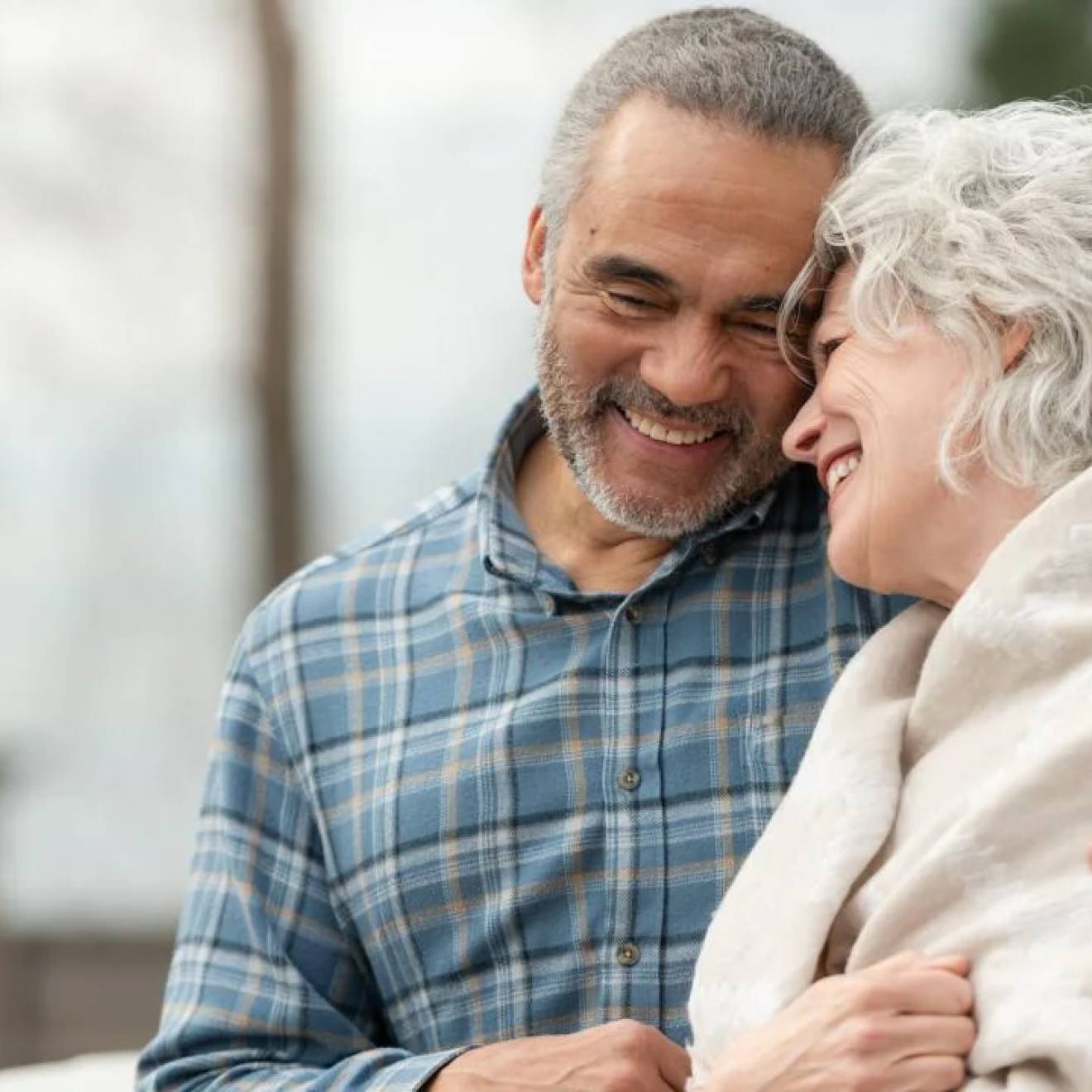 Older man and woman smile and embrace