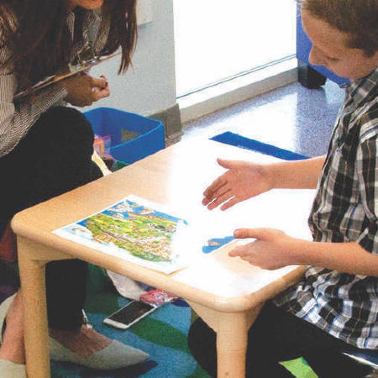 A UC Riverside SEARCH Center staffer works with an autistic child