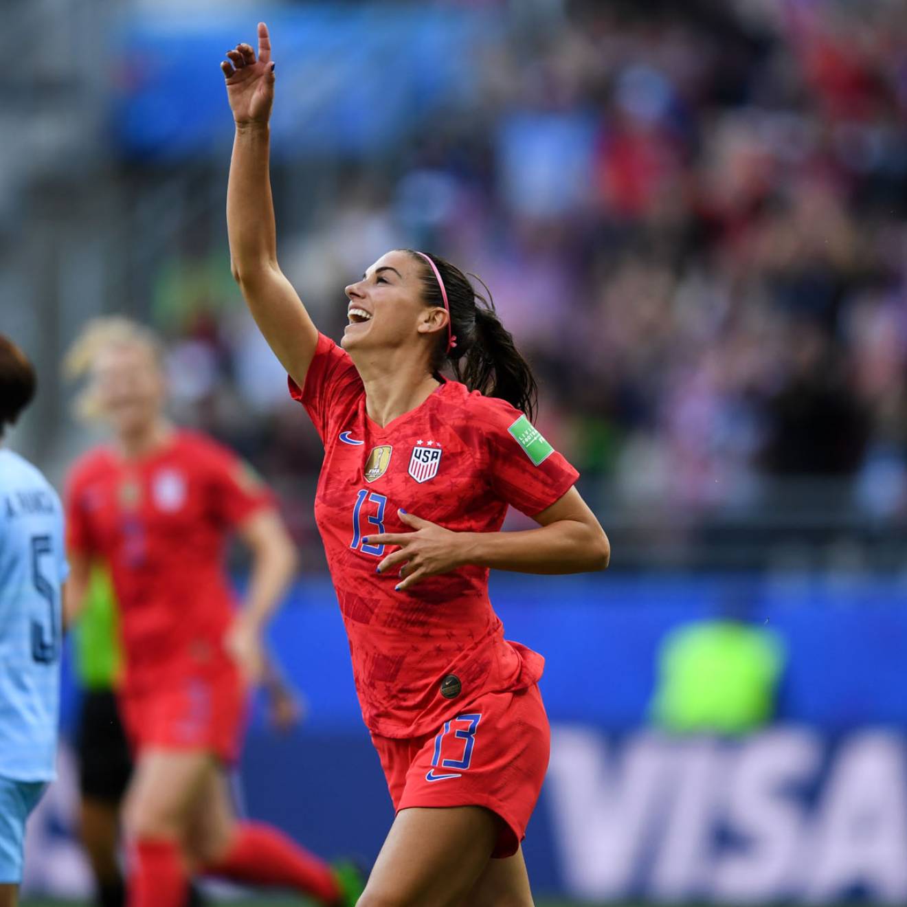 Alex Morgan pointing upward as she plays soccer for the US