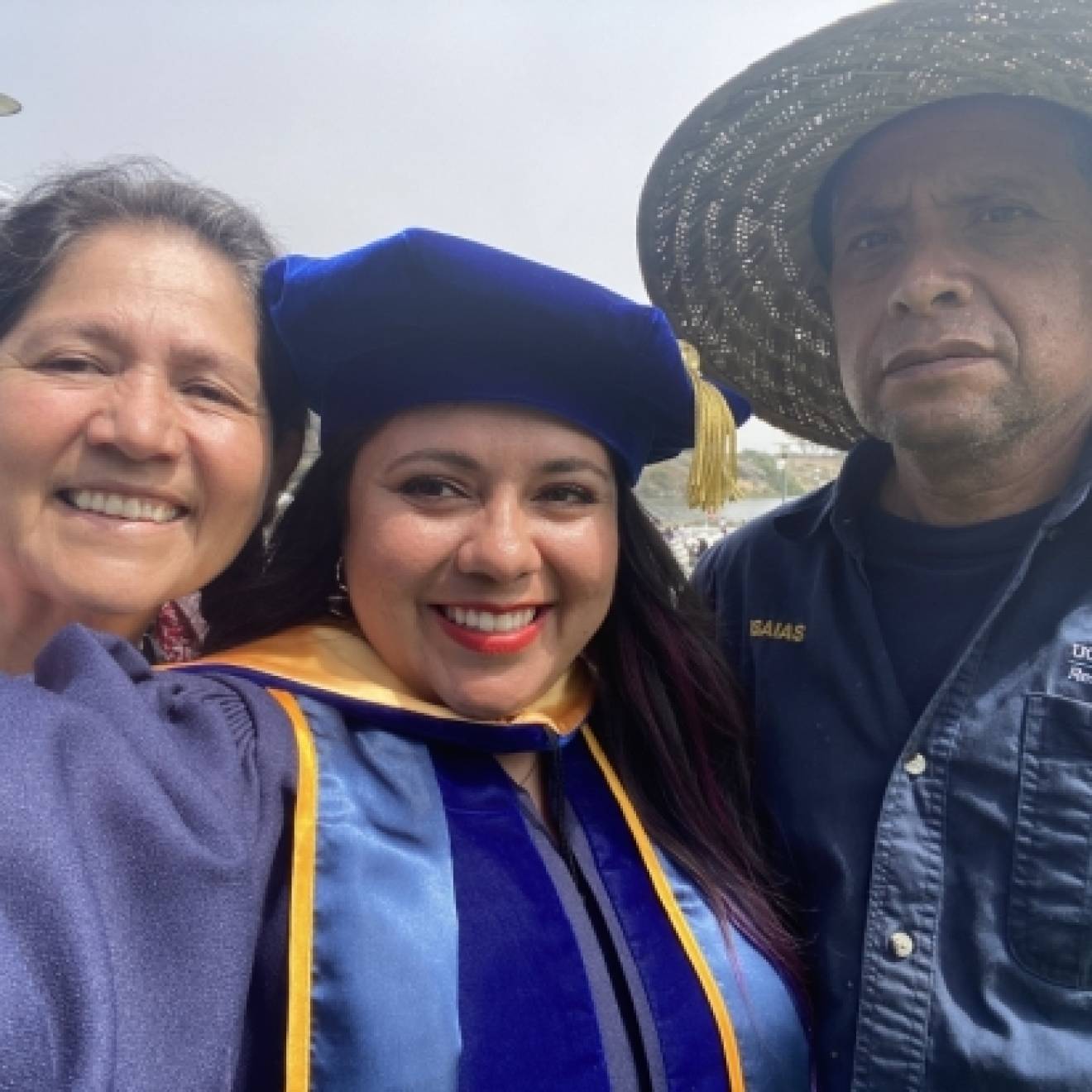 Dr. Ana Y. Guerrero in cap and gown with her parents, a selfie