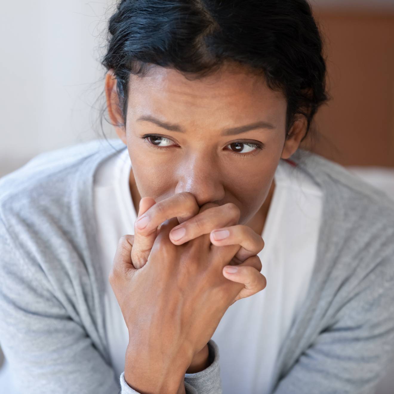 Pensive African American young woman looking in distance thinking pondering