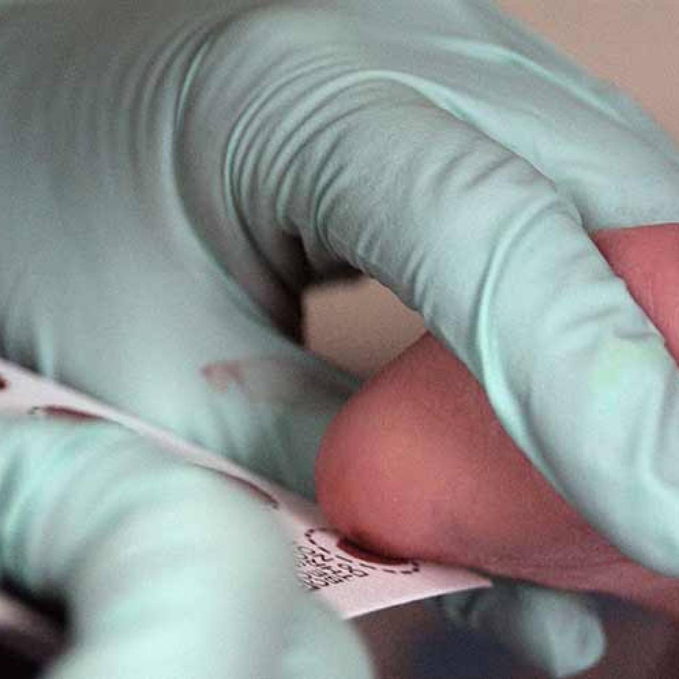 Baby's foot held by doctor for a blood test