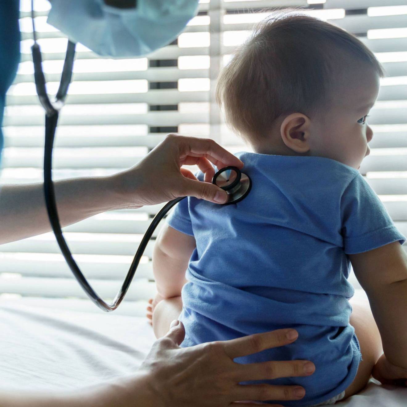 An infant getting checked by a pediatrician with a stethoscope