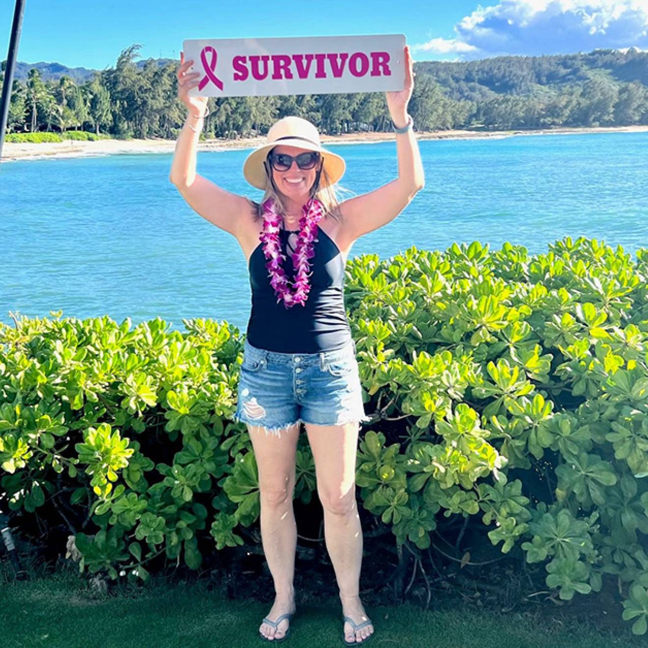 Michelle Brubaker holding up a survivor sign in Hawaii