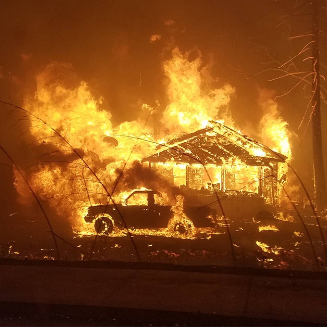 House and a truck on fire during the Camp Fire