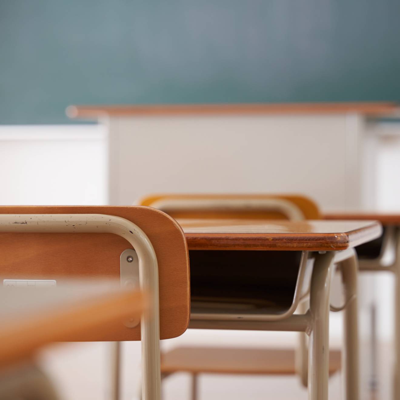 Classroom chairs and desks facing chalkboard