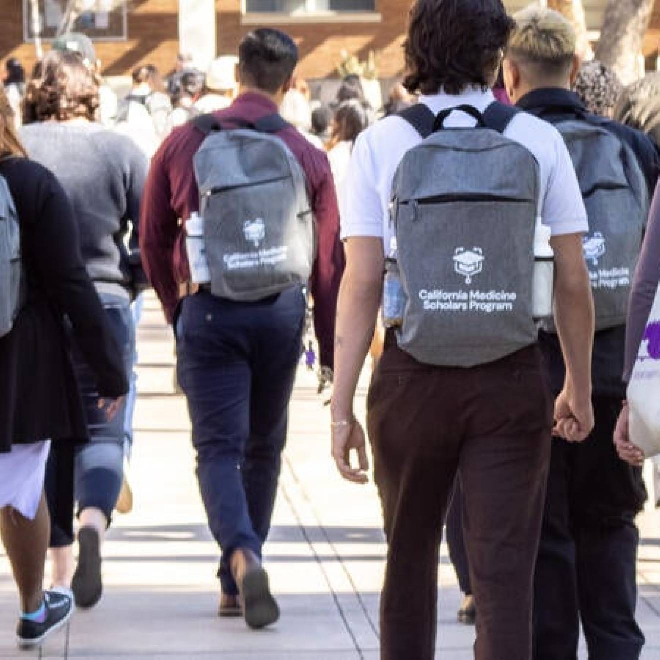 Students walking on UC Riverside campus with California Medicine Scholars Program backpacks