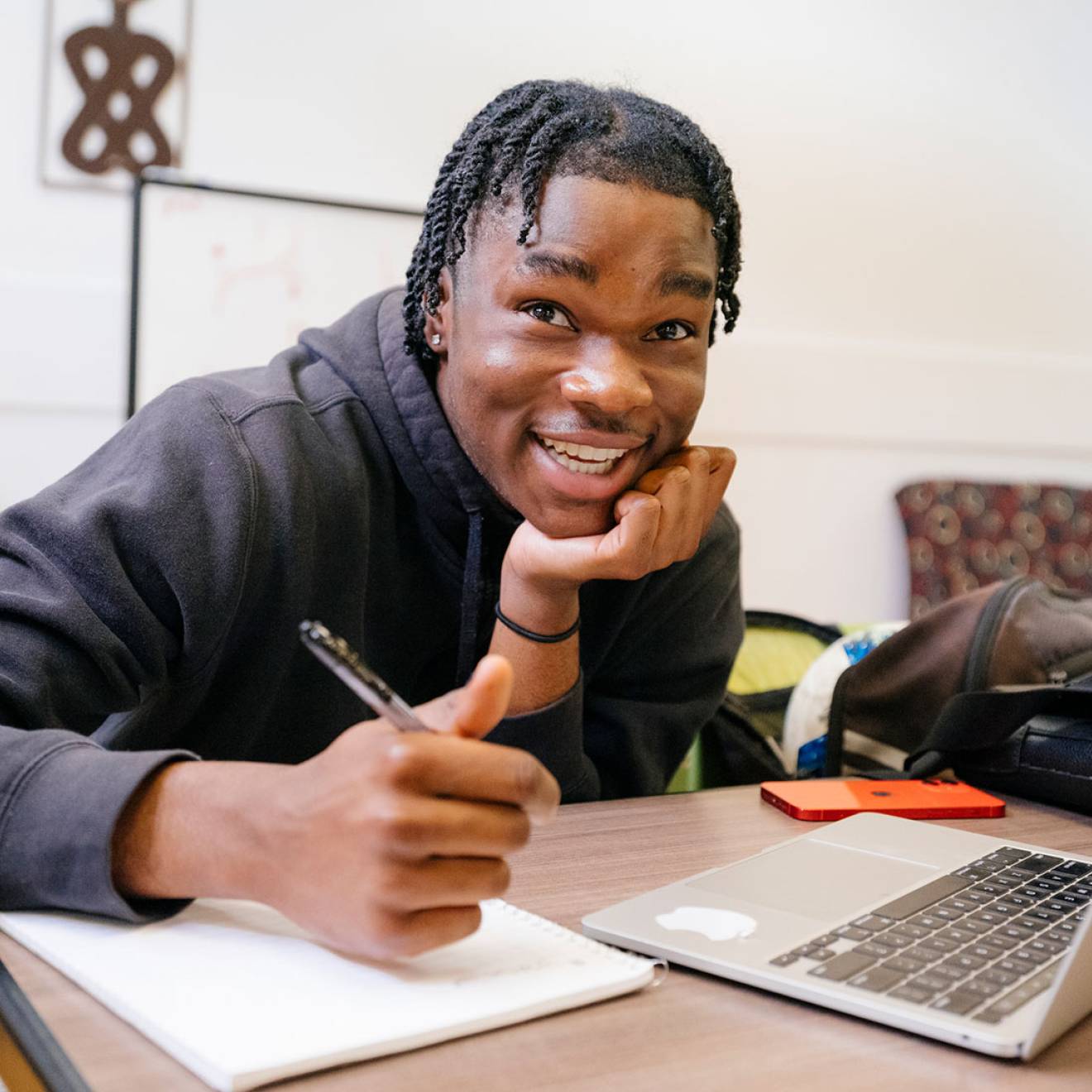 College student looks up from his notes and laptop with a quizzical look on his face