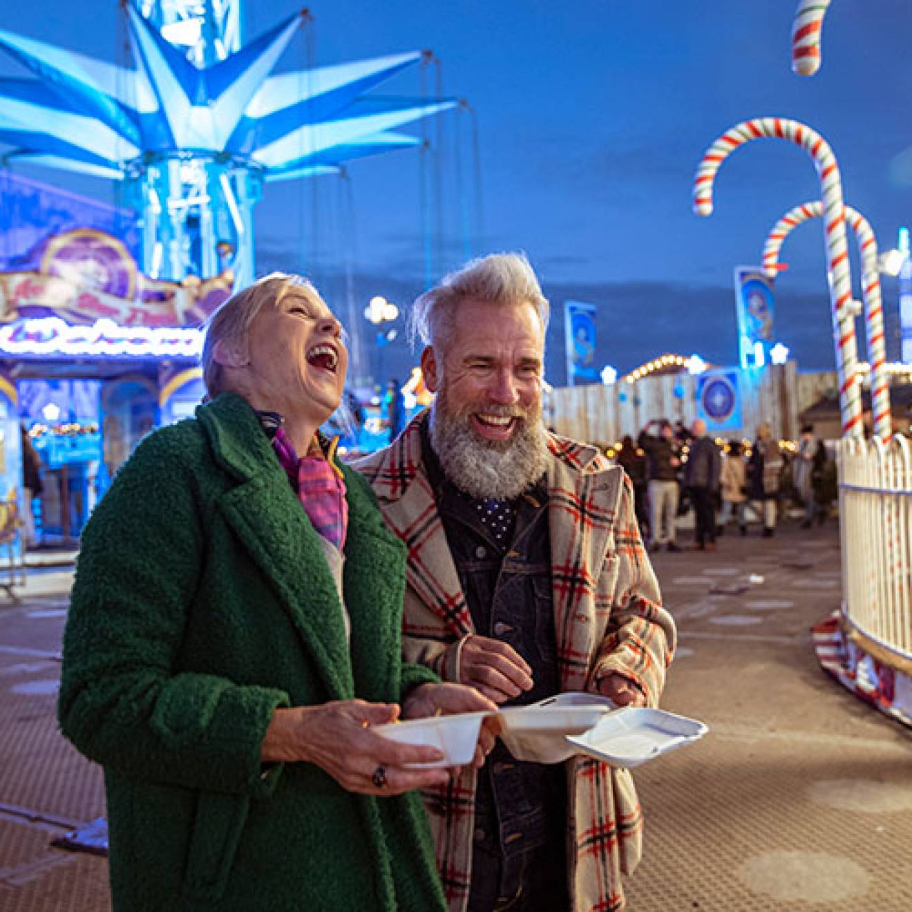 An older couple laughing at a carnival