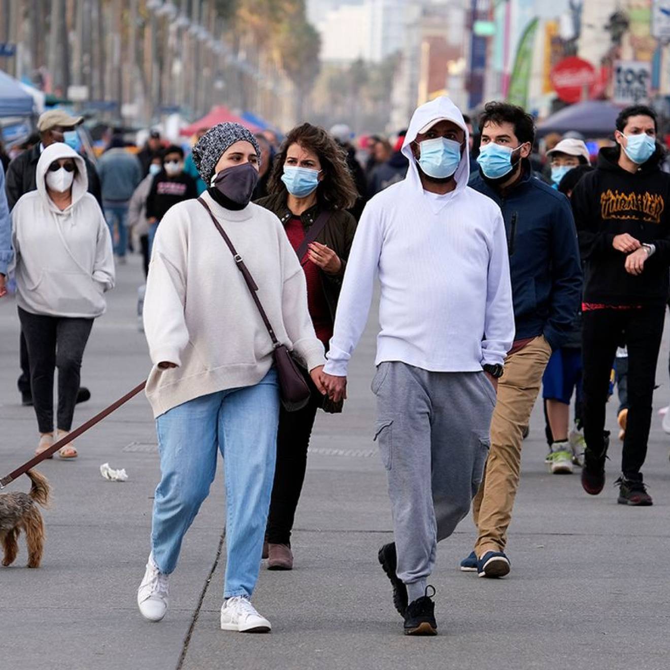 Group of people walking outside wearing masks