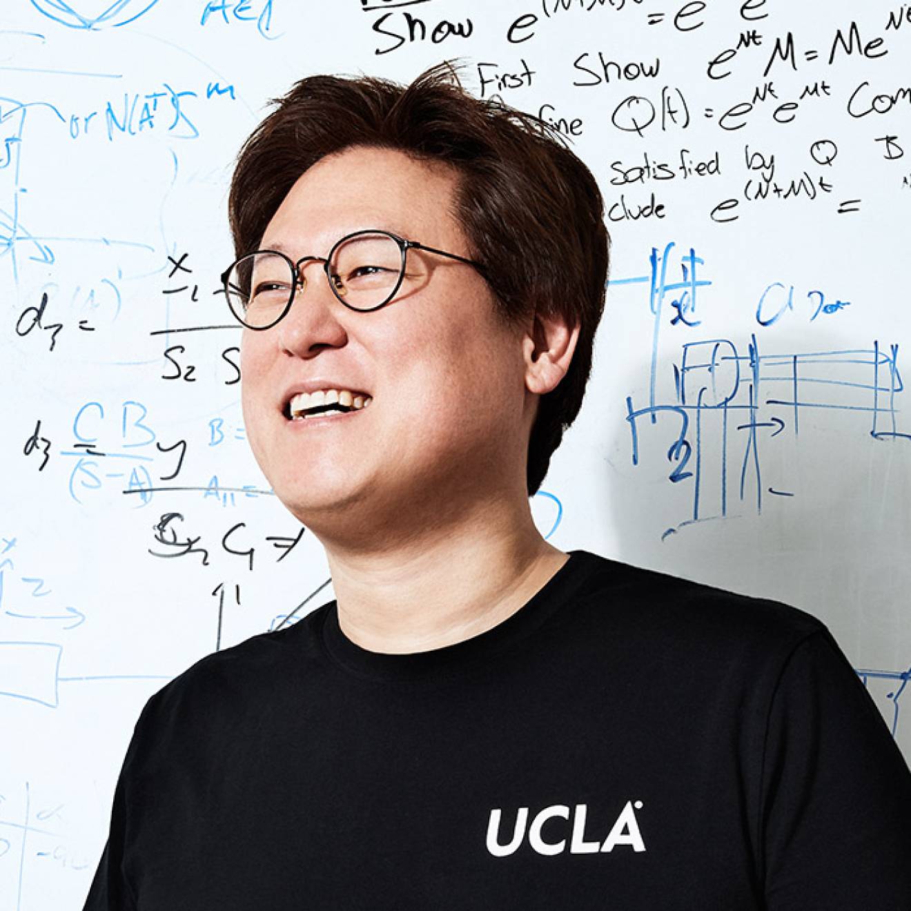 Dennis Hong in front of a whiteboard